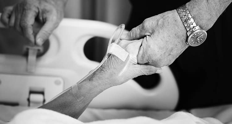 husband holding hand with his wife hospital