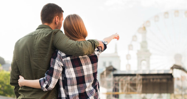 rear-view-woman-with-her-boyfriend-pointing-ferris-wheel-while