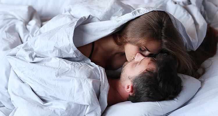 young passionate couple kissing on bed
